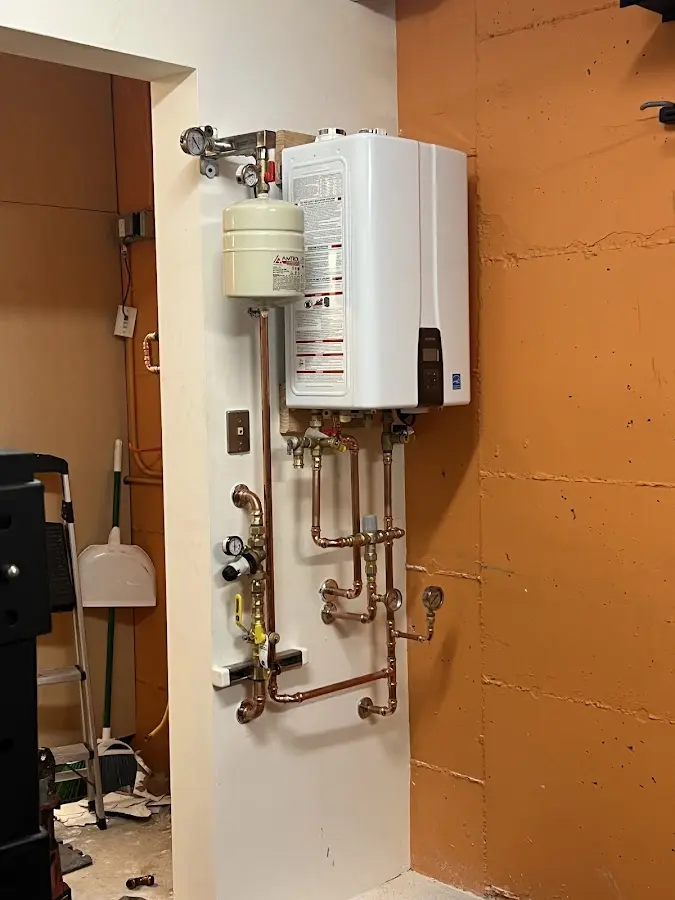 Plumbing technician inspecting water heater connections in Fortuna